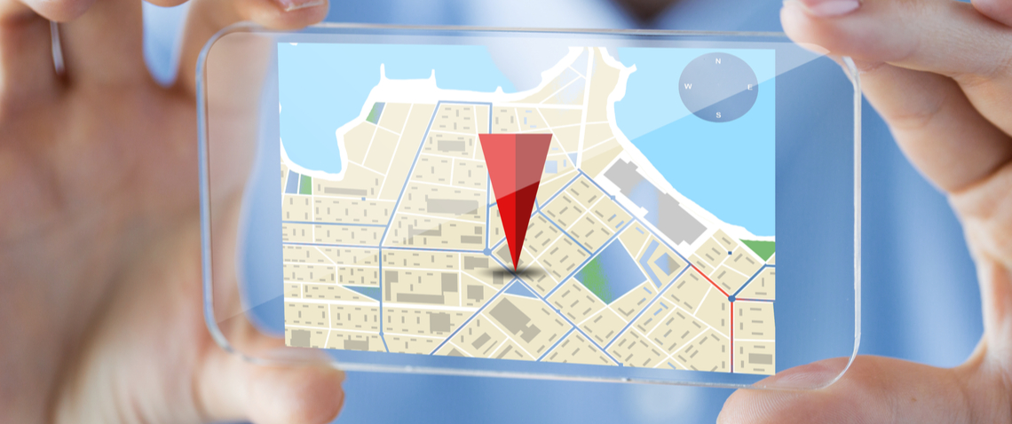 Map on a phone with a location pin in it, being held
