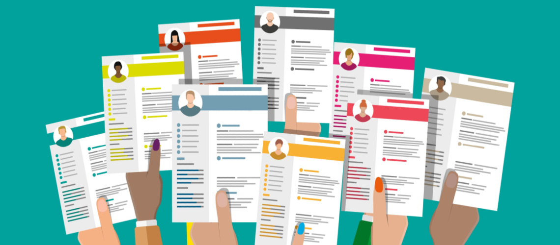 Hands holding up a variety of resumes