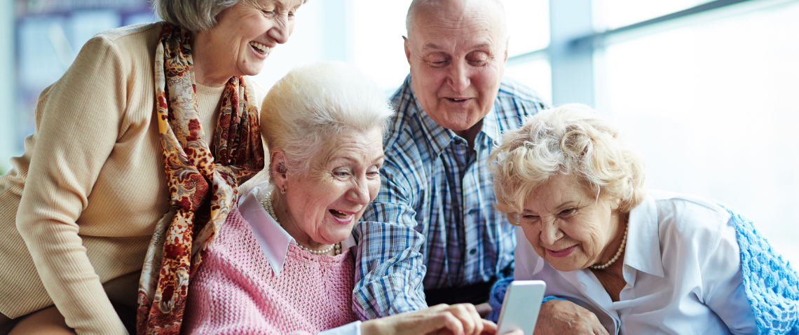 four-seniors-looking-at-iphone-happy